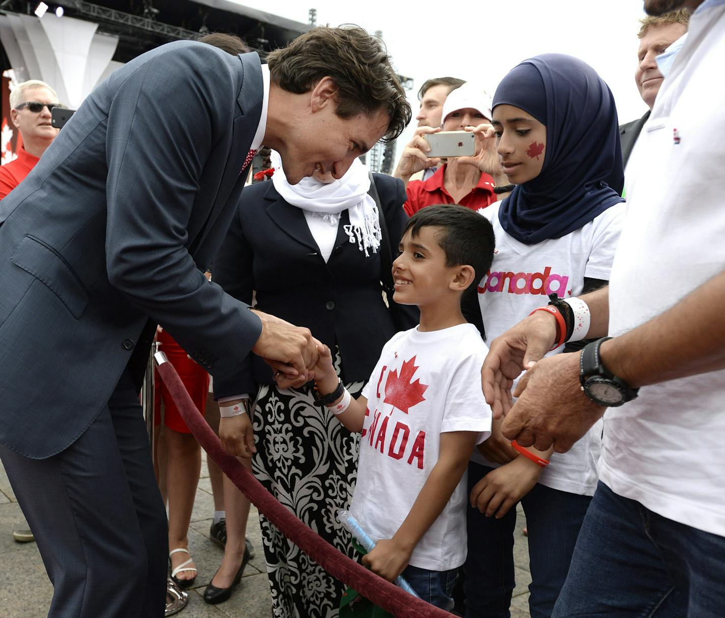 Prime Minister Justin Trudeau greets members of a Syrian refugee family during Canada Day celebrations on Parliament Hill, in Ottawa on Friday, July 1, 2016. (Justin Tang/The Canadian Press via AP) ORG XMIT: CPOTK