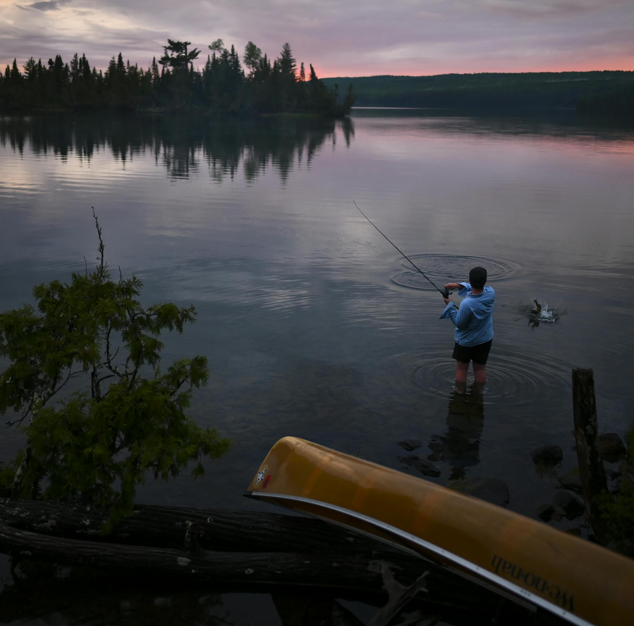 Aidan Jones caught a smallmouth bass while wading in the water off a South Lake campsite Tuesday night. ] Aaron Lavinsky ¥ aaron.lavinsky@startribune.com DAY 1 - Tony Jones, his 14-year old son Aidan , their friend Brad Shannon and Outdoors editor Bob Timmons embarked onto the Voyageurs Highway on Tuesday, June 11, 2019. Their path Tuesday took them from Gunflint Lake, to North Lake, through the Height of Land Portage eventually ending at a camp site on South Lake in the BWCA. ORG XMIT: MIN