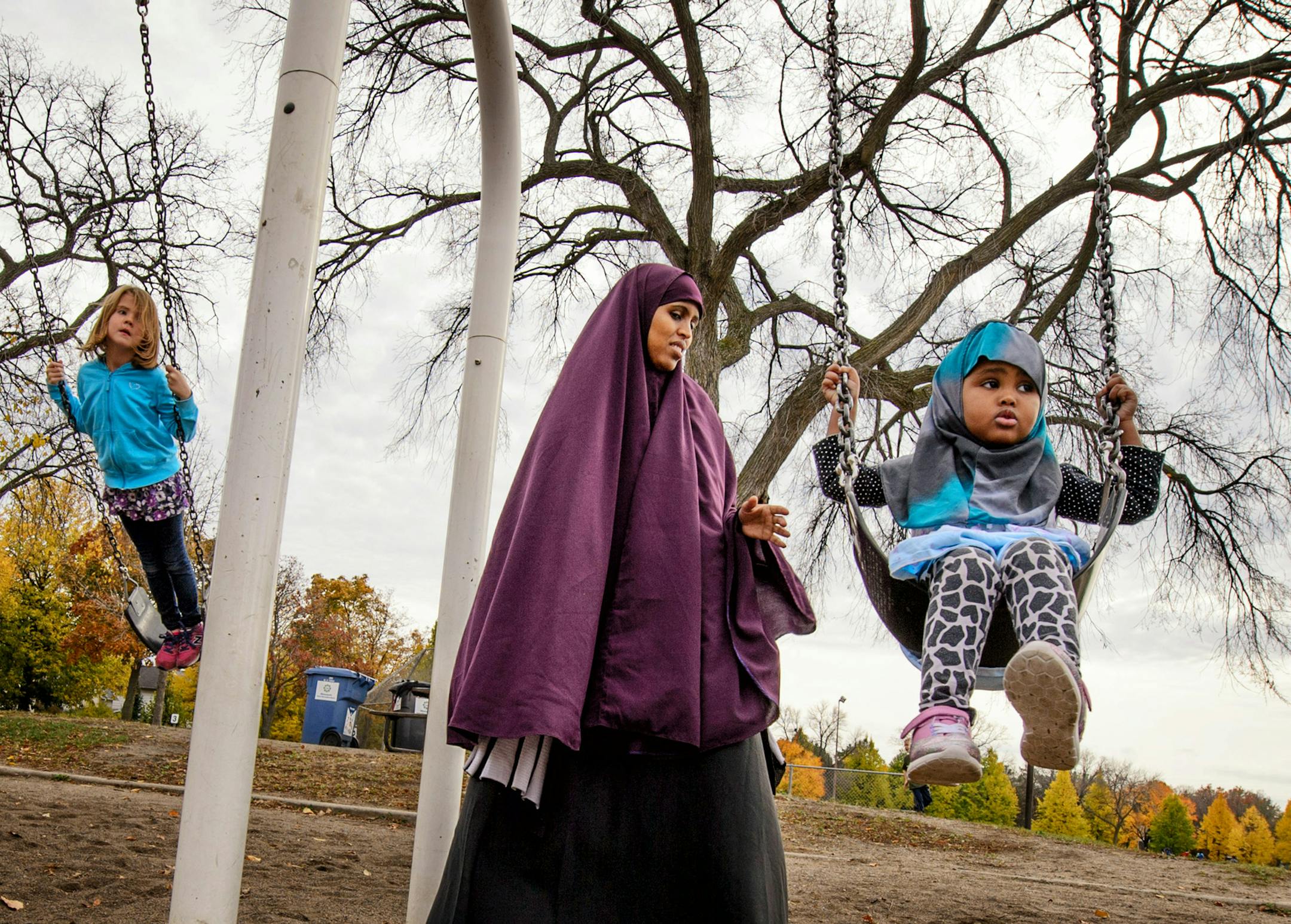 Faisa Adeys pushed her 2-year-old daughter Mumtaz in a swing in Matthews Park, Minneapolis. ] GLEN STUBBE * gstubbe@startribune.com Monday October 26, 2015 Luxton and Matthews parks and the Washburn Avenue totlot were supposed to get playground renovations next year. Phelps was to get a wading pool overhaul. Lyndale Farmstead and Painter parks were slated for building improvements. But all are being shoved off at least a year, along with 10 other future projects under a revamped capital proposal