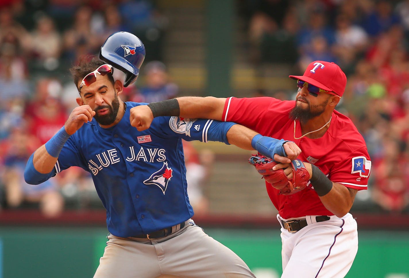 The Blue Jays' Jose Bautista got punched by Rangers second baseman Rougned Odor after Bautista slid into second in the eighth inning Sunday.