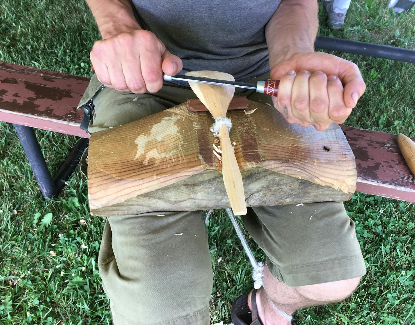 Charlie (Little Bird) Thompson of Minneapolis attacks the giant spoon log. Shaping the bowl of a spoon (yes, spoons have bowls). The spoonmakers are at work during the 11th annual Spoon Gathering in Milan, Minn.