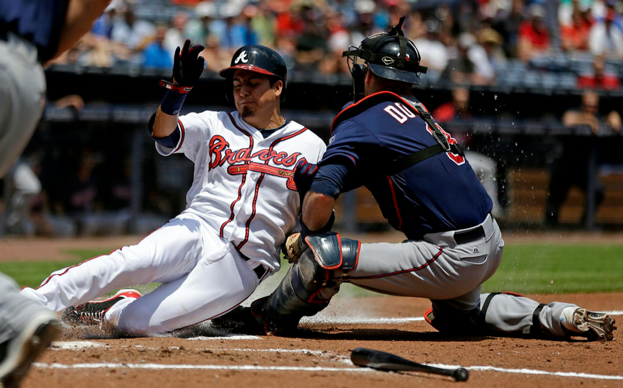 Atlanta Braves' Ramiro Pena, left, is tagged out at home plate by Minnesota Twins catcher Ryan Doumit, while attempting to score off a fly ball by Freddie Freeman in the first inning of a baseball game, Wednesday, May 22, 2013, in Atlanta. (AP Photo/David Goldman)