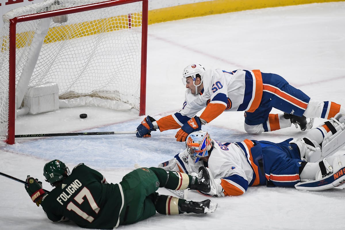New York Islanders defenseman Adam Pelech (50) was unable to stop the puck as Minnesota Wild left wing Marcus Foligno (17) scored a goal on New York I