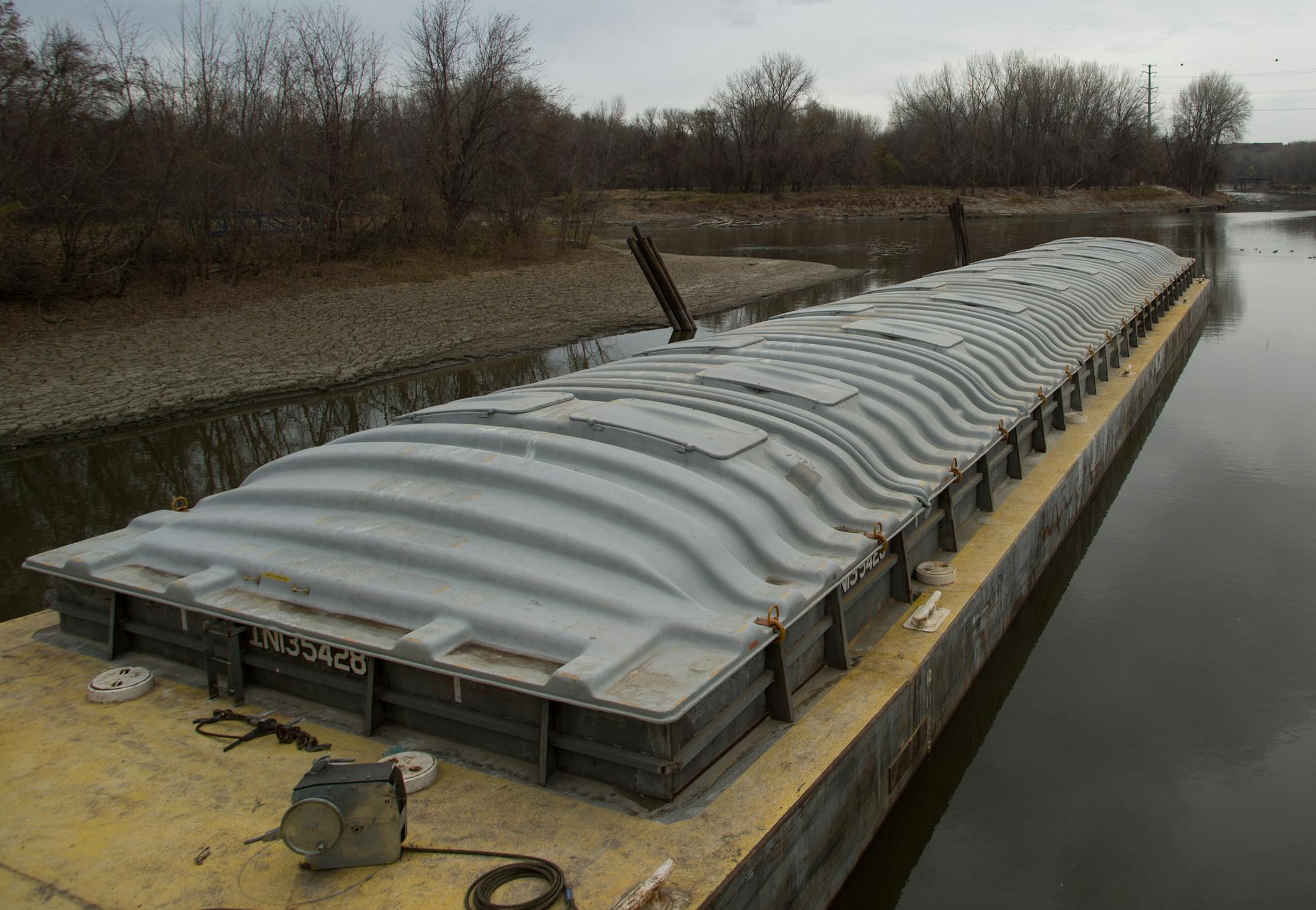 A river barge floats idly on the Minnesota River after being loaded with beans on Friday. ] AARON LAVINSKY • aaron.lavinsky@startribune.com Photographing the process of unloading grain from trucks onto river barges at the CHS Grain Terminal in Savage on Friday, November 7, 2014.