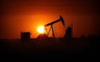 The sun set over the Bakken Oil Formation, behind an oil well near Williston in 2013. North Dakota, the nation's second-largest oil and gas producer, 