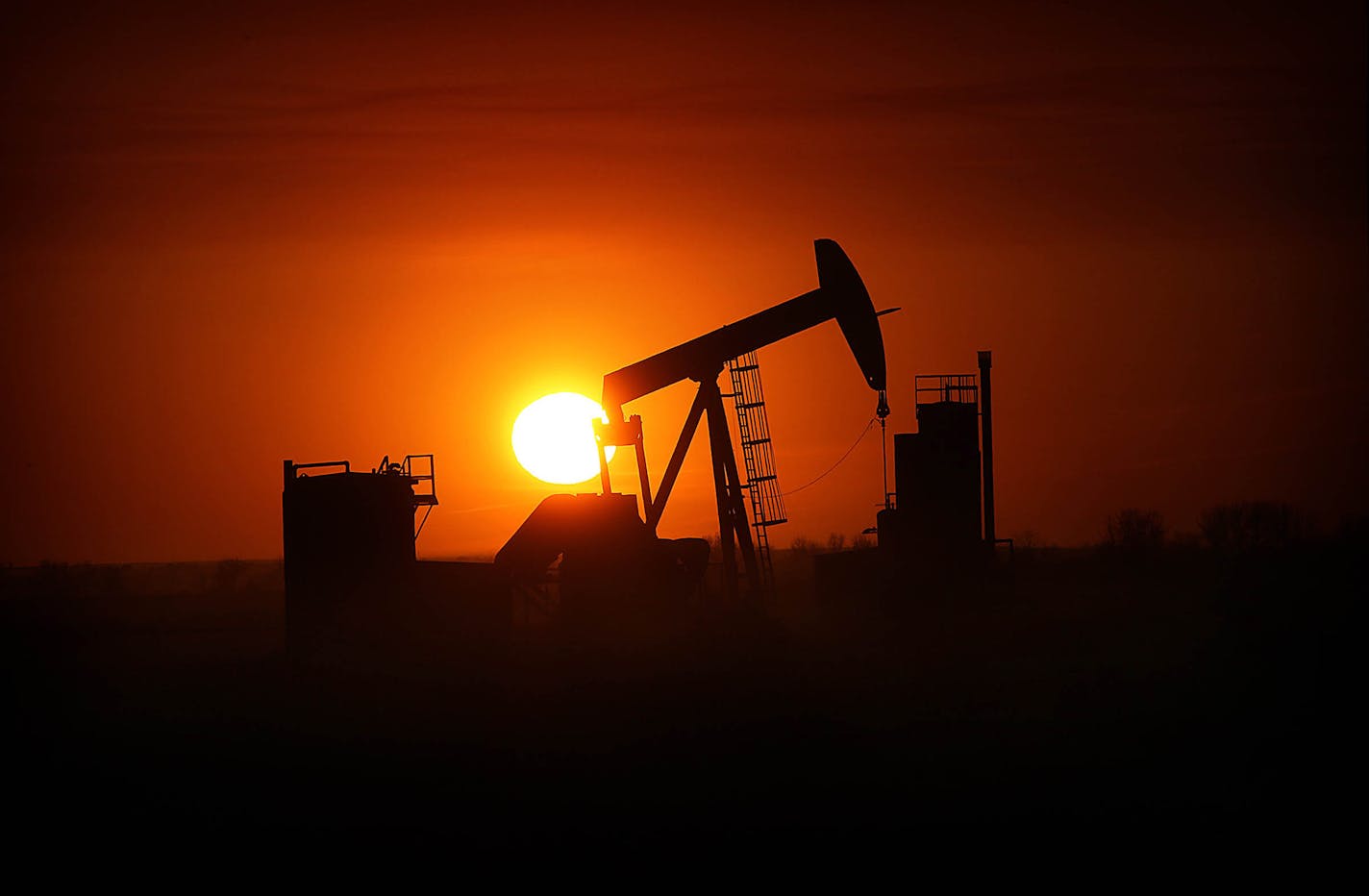 The sun set over the Bakken Oil Formation, behind an oil well near Williston in 2013. North Dakota, the nation's second-largest oil and gas producer, churned out 1.22 million barrels of oil per day in September, up from 1.17 million the previous month.