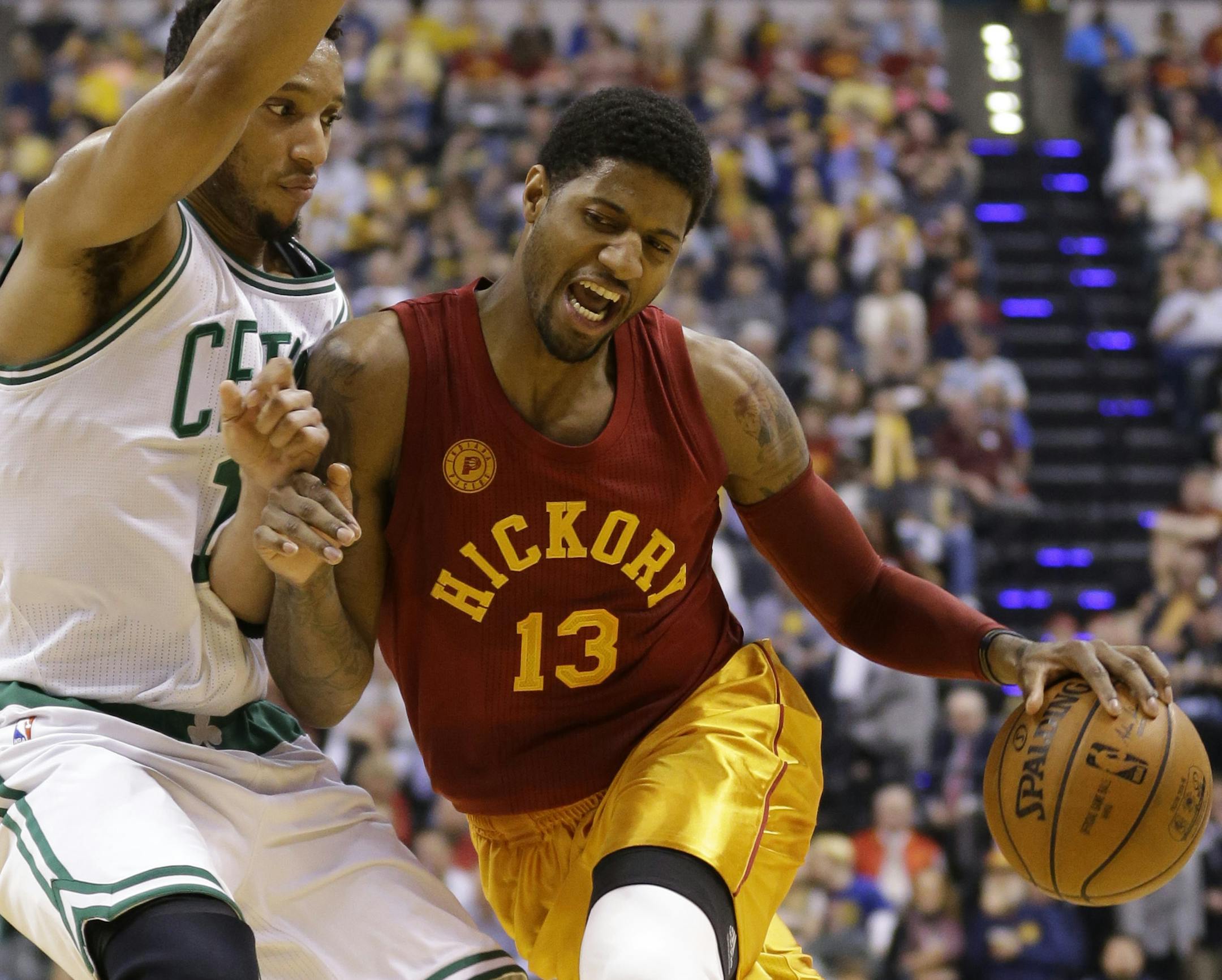 Indiana Pacers forward Paul George (13) drives on Boston Celtics guard Evan Turner (11) during the first half of an NBA basketball game in Indianapolis, Tuesday, March 15, 2016. (AP Photo/Michael Conroy)
