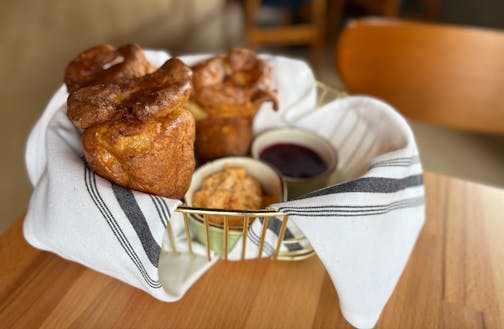 A basket of popovers with compound butter.