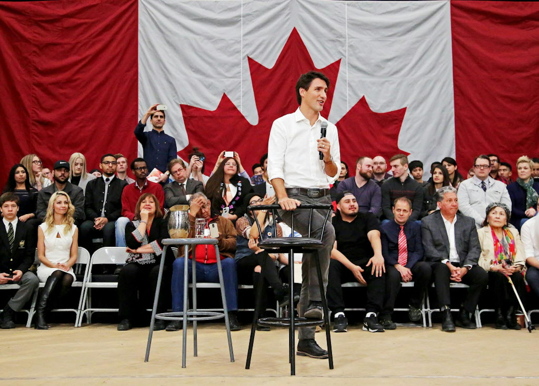 Canadian Prime Minister Justin Trudeau participated in a town hall meeting at the University of Winnipeg Thursday, Jan. 26, 2017, in Winnipeg, Canada. Among those seated behind Trudeau was Yahya Samatar, red sweater, a Somali man who swam across the Red River from Minnesota to North Dakota and in cover of darkness walked across the U.S. border to Manitoba, Canada on Aug. 5, 2016, after earlier that year being detained in the U.S. and denied refugee status. A Canadian court hearing later ruled th