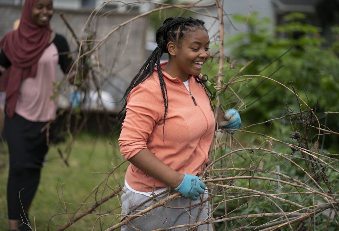 Amal Bare, 14, left and Jazmine Bolden, 15, carried brush from the Urban Oasis Community garden at 37th and Fremont Avenue N. on Wednesdayin Minneapolis.