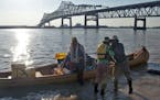 Near the Horace Wilkinson Bridge in an industrial stretch of Baton Rouge, La., members of an expedition on the Lower Mississippi River disembark from 