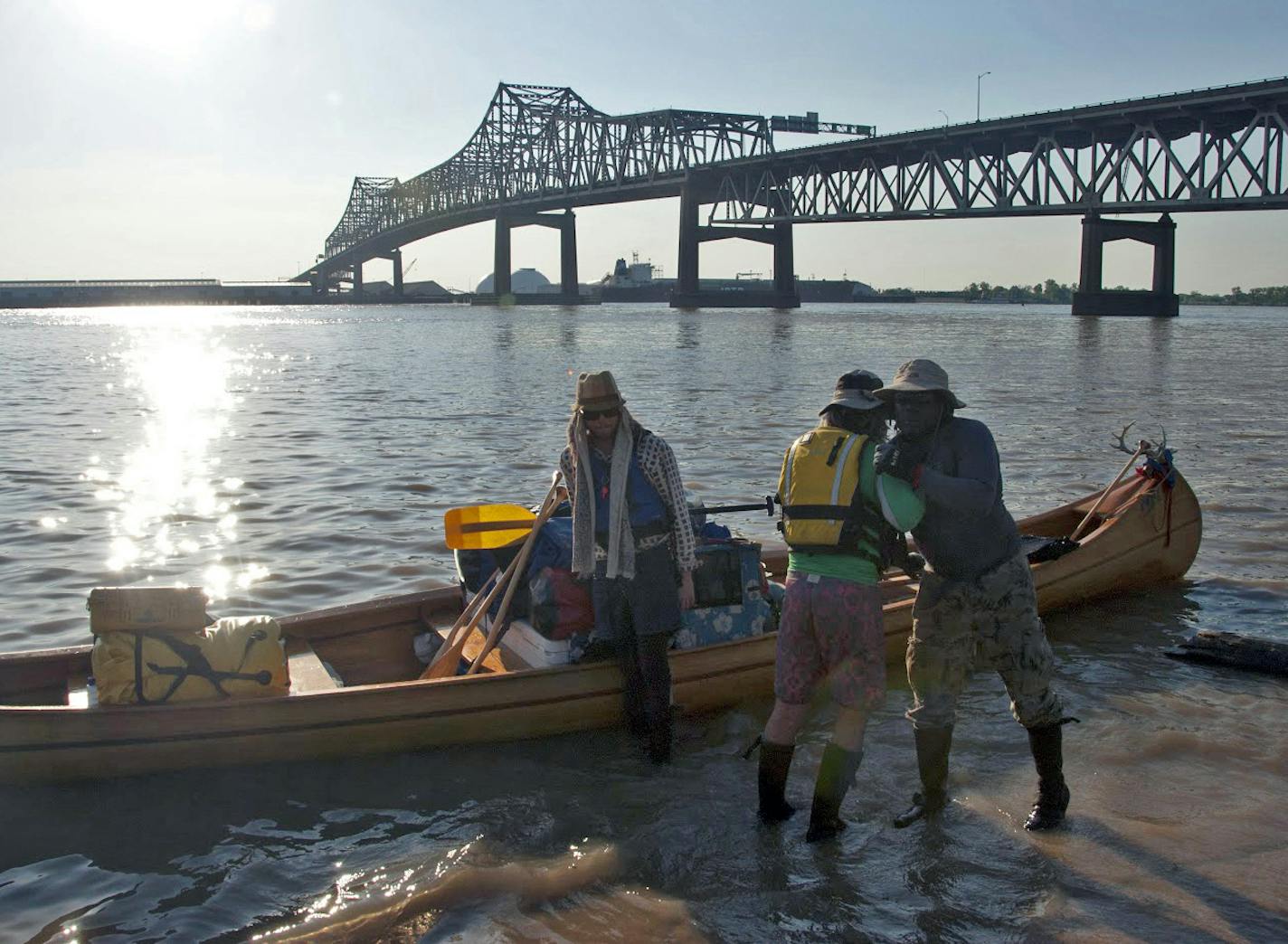 Near the Horace Wilkinson Bridge in an industrial stretch of Baton Rouge, La., members of an expedition on the Lower Mississippi River disembark from a gear-laden canoe.