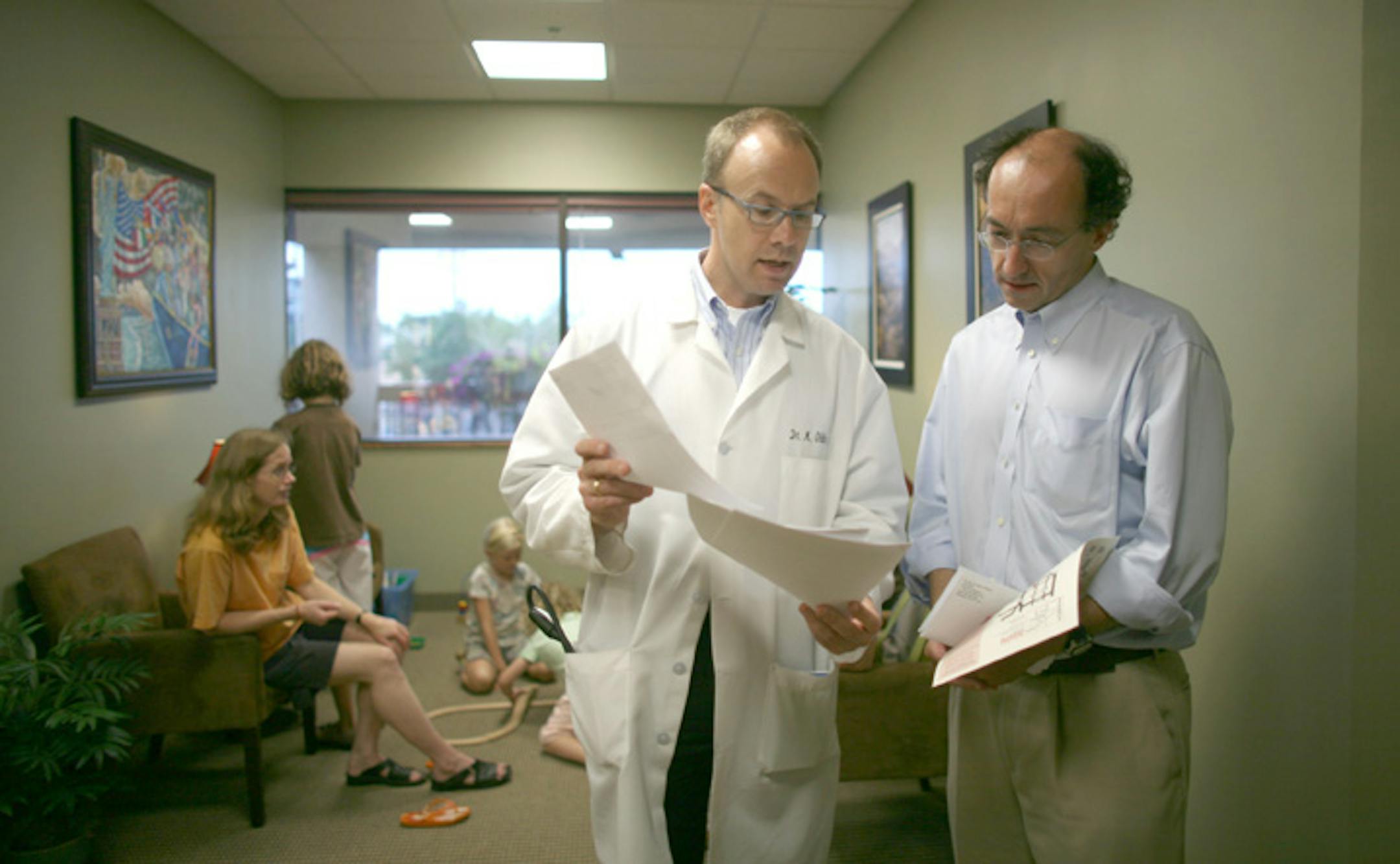 Michael Oldenburg explained to Gerard Smyth what to do with paperwork from exams Smyth and his family had on Wednesday. The Smyth family had been living in the U.K. and required physicals for immigration applications. Oldenburg's 2,000 square-foot clinic is located in Calhoun Village above a Hollywood Video store.