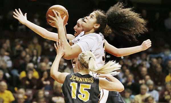 Amanda Zahui B. (32) shoots as Whitney Jennings (15) defends during an NCAA college basketball game in Minneapolis.