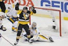 The Penguins' Jake Guentzel, front, celebrated a goal by teammate Evgeni Malkin in front of Predators goalie Pekka Rinne during the first period in Ga