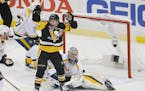 The Penguins' Jake Guentzel, front, celebrated a goal by teammate Evgeni Malkin in front of Predators goalie Pekka Rinne during the first period in Ga