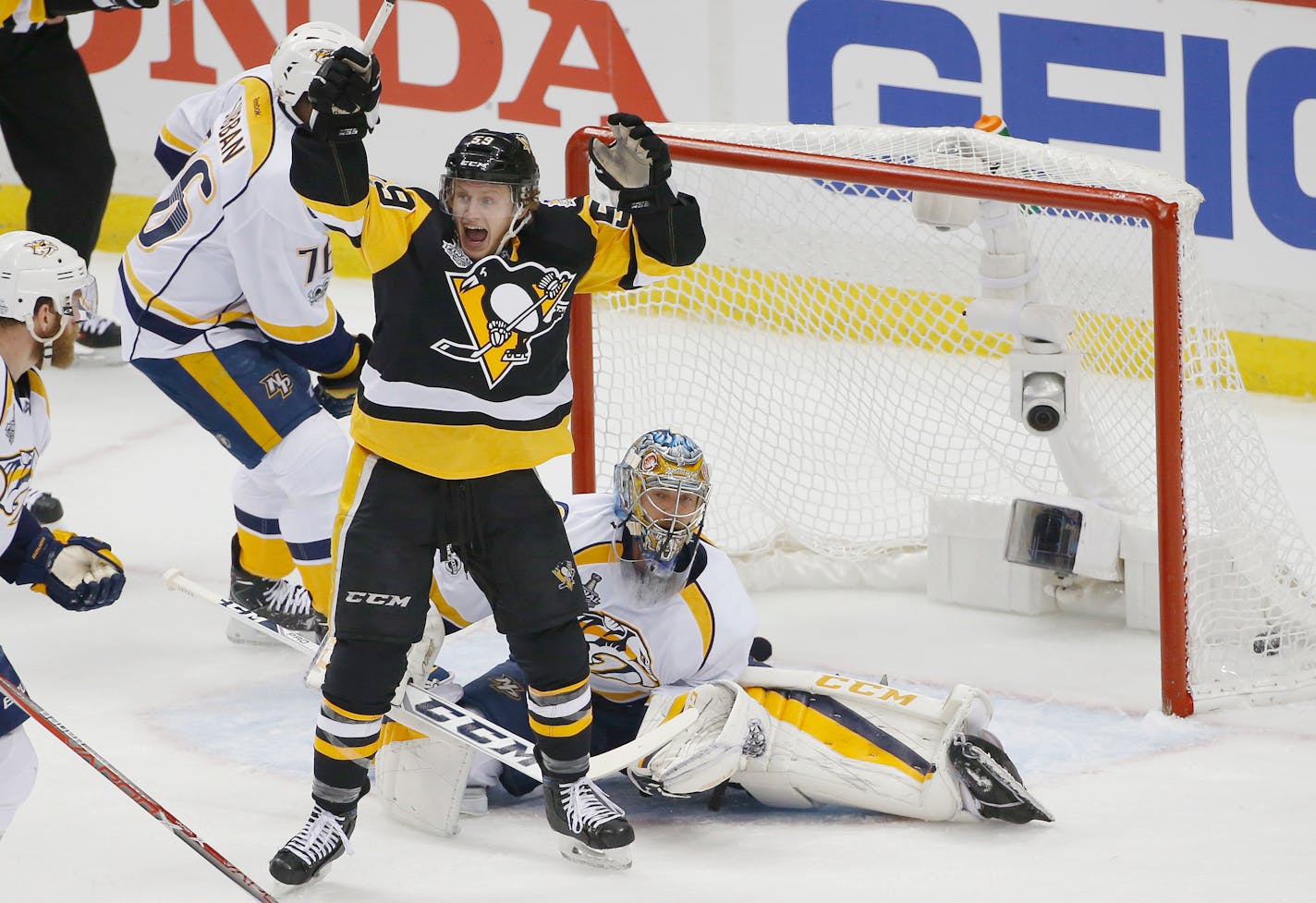 The Penguins' Jake Guentzel, front, celebrated a goal by teammate Evgeni Malkin in front of Predators goalie Pekka Rinne during the first period in Game 1 of the Stanley Cup Final on Monday.