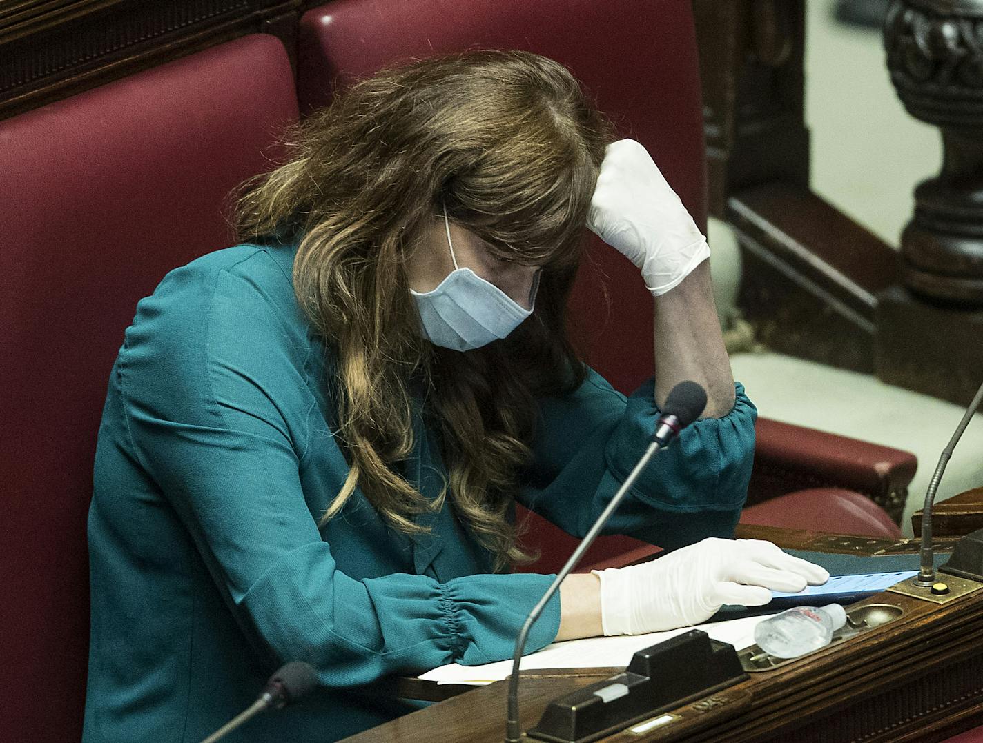 Lawmaker Maria Teresa Baladini wears a face mask and gloves during a session in parliament on financial relief, in Rome, Wednesday, March 11, 2020. Italy is mulling even tighter restrictions on daily life and has announced billions in financial relief to cushion economic shocks from the coronavirus. For most people, the new coronavirus causes only mild or moderate symptoms, such as fever and cough. For some, especially older adults and people with existing health problems, it can cause more seve