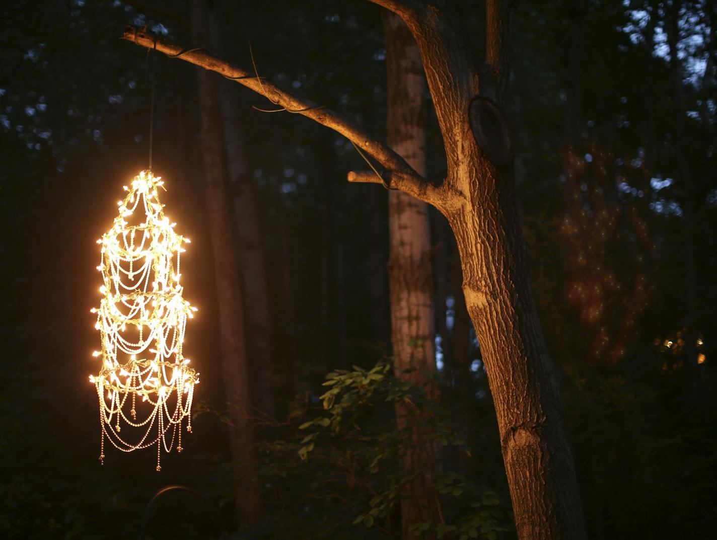 A beaded chandelier hangs from a branch above the Groths' Eagan garden.