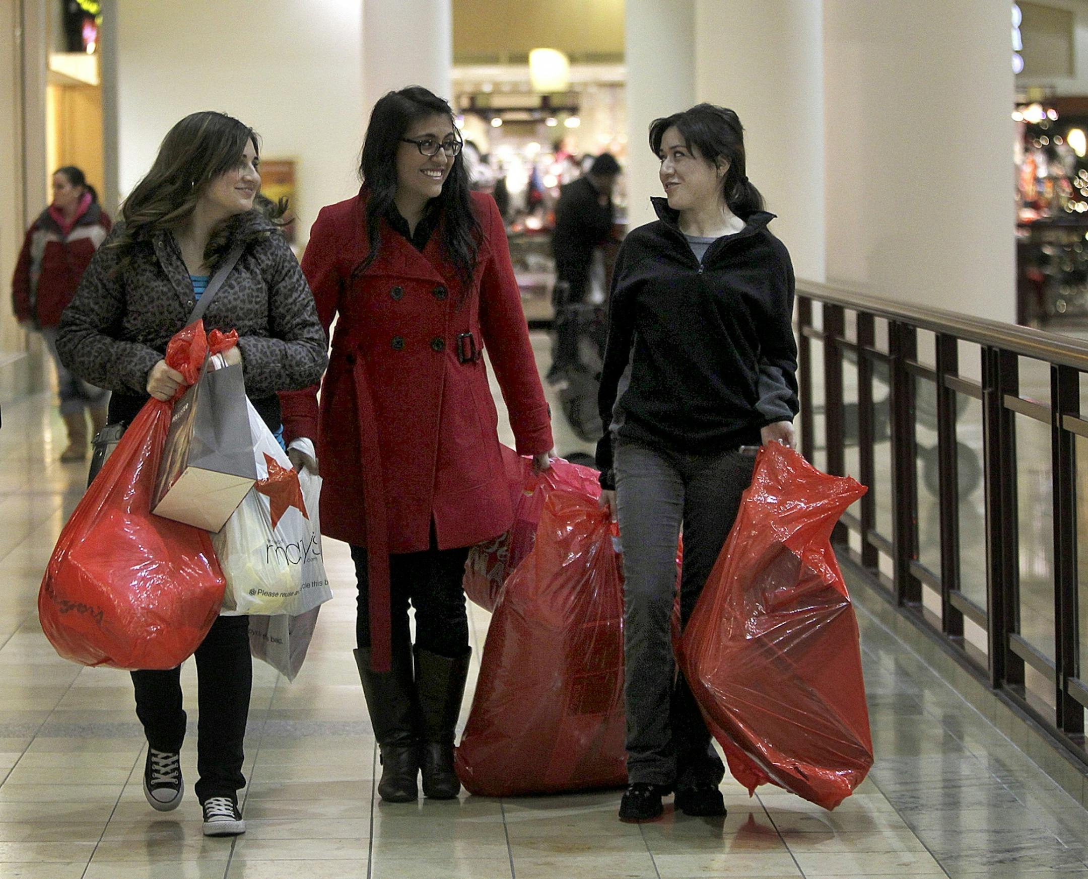 Sisters from left, Yantzy Escoto, Jimena Escoto and Cynthia Escoto of West St. Paul, helped each other with their shopping bags at Rosedale Mall.