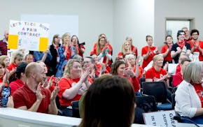 Attendees wore red shirts in support of teachers and applauded after a speaker addressed the board during a school board meeting at the Lakeville Dist