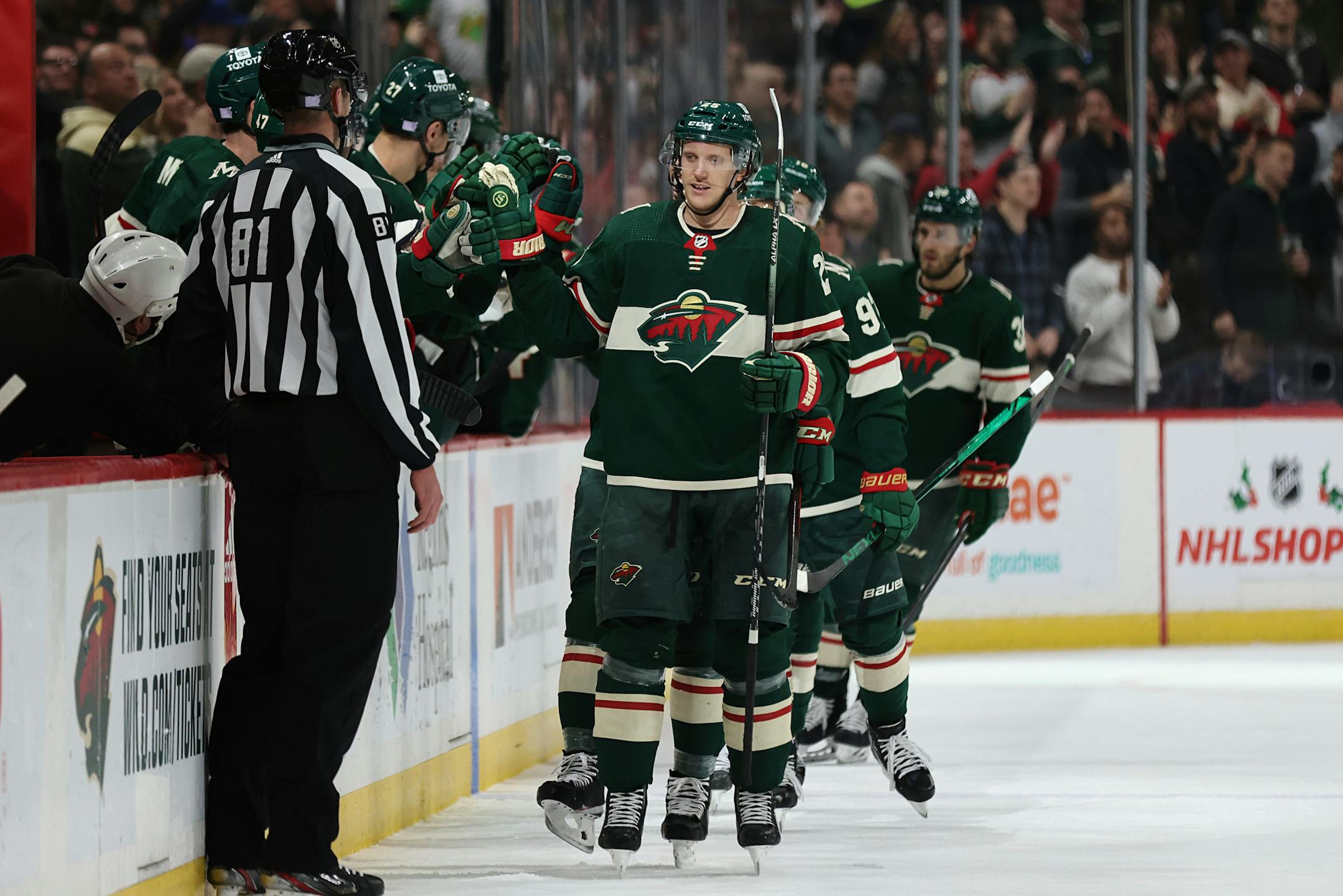 Minnesota Wild defenseman Jonas Brodin (25) high-fives teammates on the bench after scoring a goal against the Arizona Coyotes during the second period of an NHL hockey game Tuesday, Nov. 30, 2021, in St. Paul, Minn. Minnesota won 5-2. (AP Photo/Stacy Bengs)