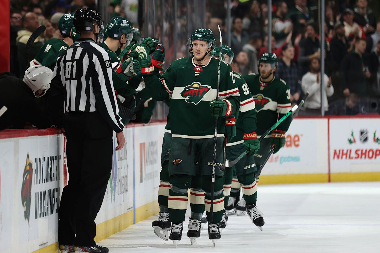 Minnesota Wild defenseman Jonas Brodin (25) high-fives teammates on the bench after scoring a goal against the Arizona Coyotes during the second period of an NHL hockey game Tuesday, Nov. 30, 2021, in St. Paul, Minn. Minnesota won 5-2. (AP Photo/Stacy Bengs)