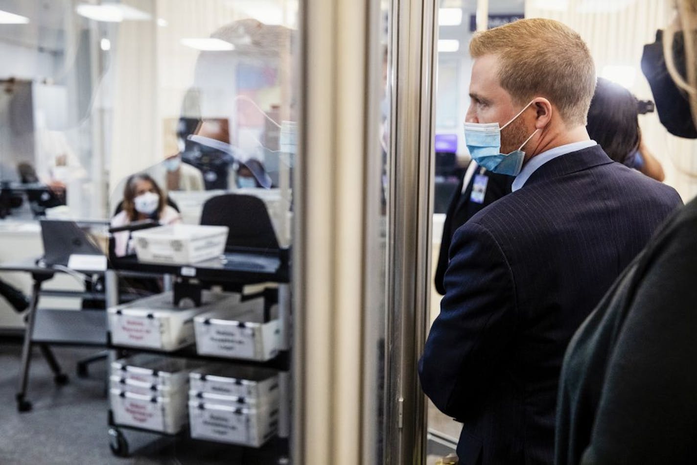 Lawyers for both Democratic and Republican Parties monitor election officials reviewing ballots at the Miami-Dade County Elections Department in Doral, Fla., Nov. 2, 2020. With voting coming to a close, the Trump and Biden campaigns, voting rights organizations and conservative groups are raising money and dispatching armies of lawyers for what is shaping up to be a state-by-state, county-by-county legal battle over which ballots will be allowed to count.