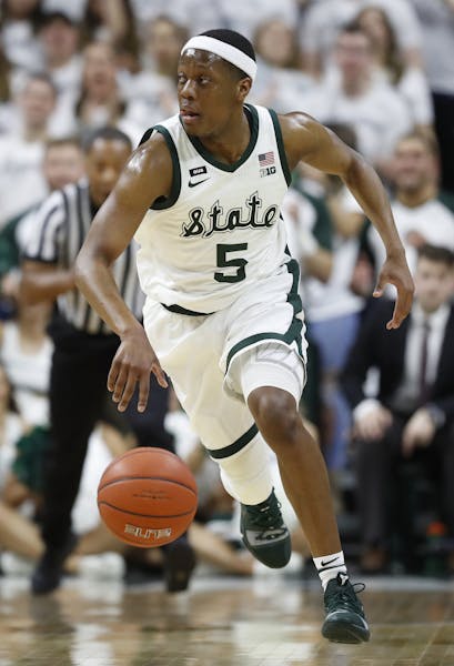 Michigan State guard Cassius Winston brings the ball up court during the first half of an NCAA college basketball game against Michigan, Saturday, Mar