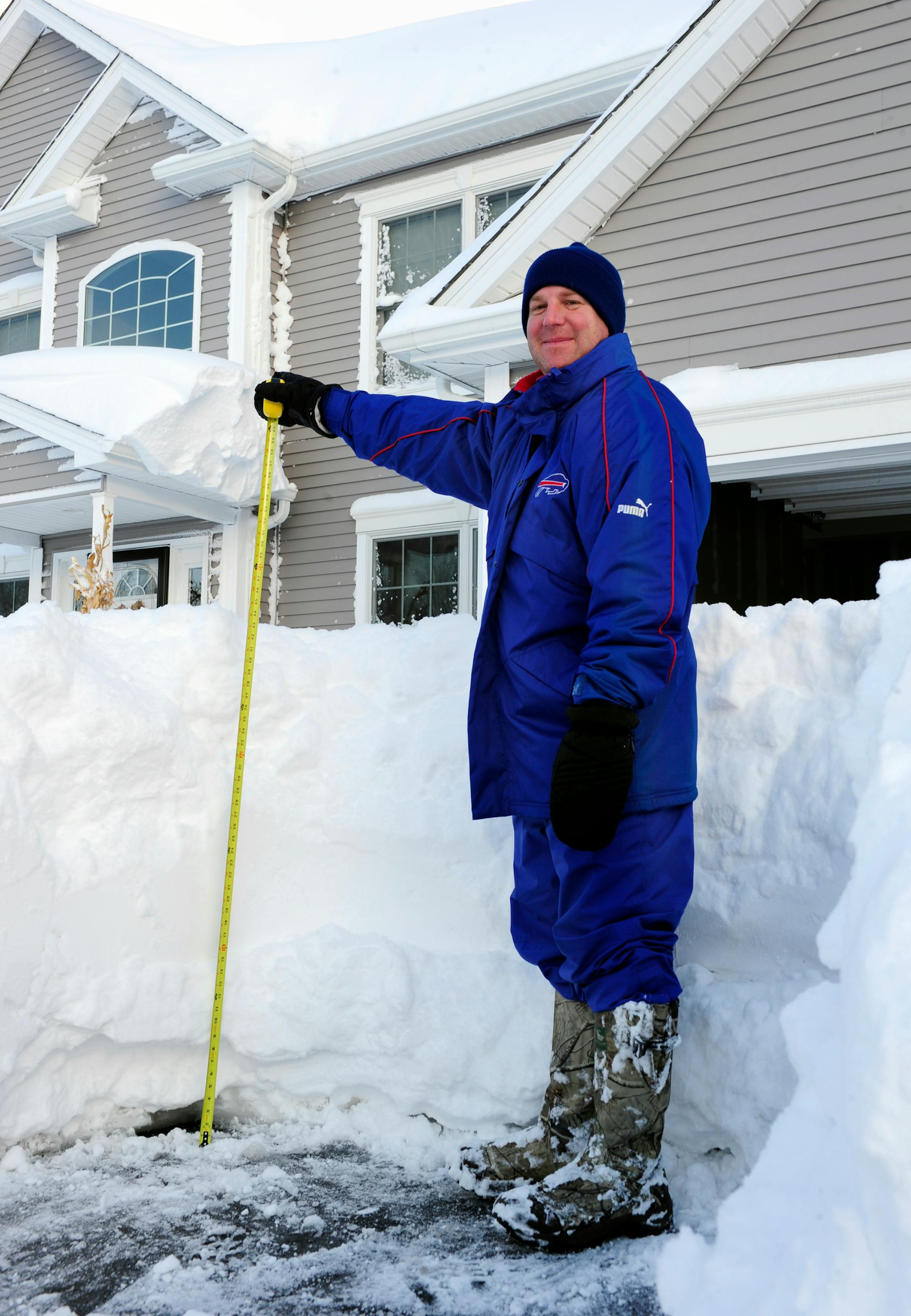 Art Hauret pauses after he measures the nearly four foot accumulation of snow in his driveway on Summerfield Drive in Lancaster, N.Y. Wednesday, Nov. 19, 2014. A ferocious storm dumped massive piles of snow on parts of upstate New York, trapping residents in their homes and stranding motorists on roadways, as temperatures in all 50 states fell to freezing or below. (AP photo/Gary Wiepert)