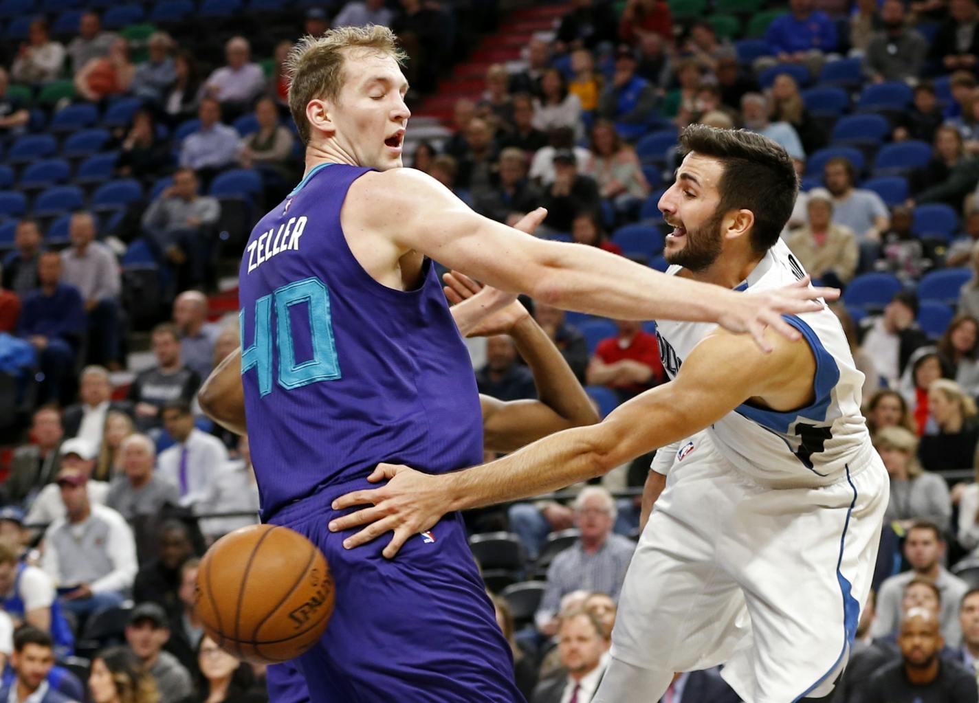 Minnesota Timberwolves' Ricky Rubio, right, of Spain, passes the ball behind Charlotte Hornets' Cody Zeller.