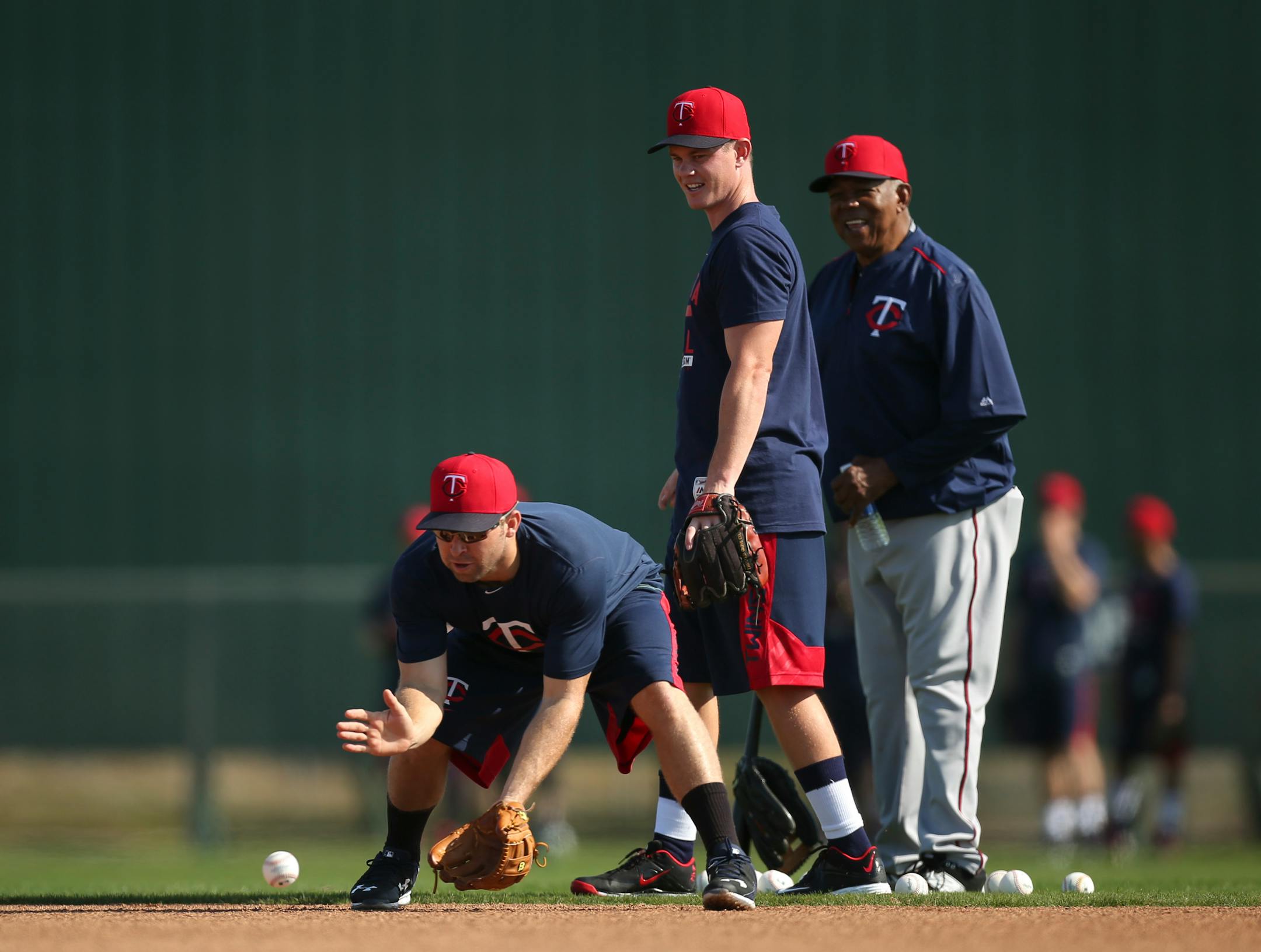 Twins second baseman Brian Dozier fielded a grounder under the watchful eyes of James Beresford and Tony Oliva during spring training in February.