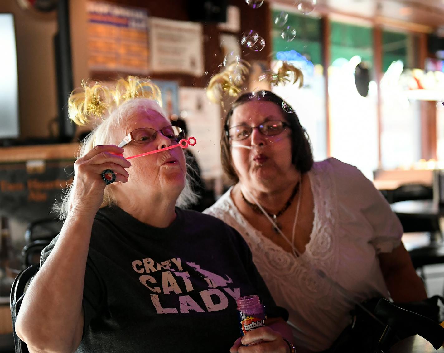 Darlene Rasmussen, left, a customer of over 35 years, and Donna Hatton, a customer of 20 years, blew bubbles during their friend Peggy's 69th birthday party Friday. ] AARON LAVINSKY &#xef; aaron.lavinsky@startribune.com Around the Twin Cities, notably chefs and restaurateurs are snatching up old diving bars and remaking them -- into something inspired by the past, but of the future too. We photograph Mortimer's Bar and Restaurant on Friday, August 4, 2017 in Minneapolis.