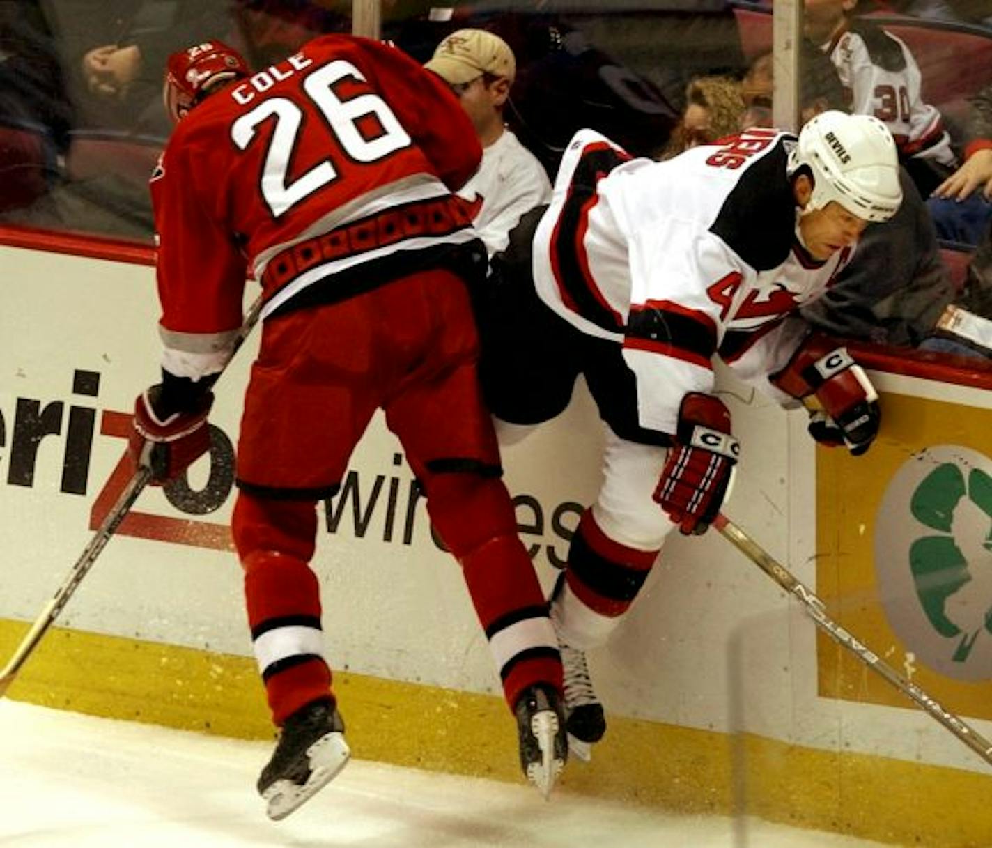 In this March 23, 2002, file photo, Carolina Hurricanes' Erik Cole (26) checked New Jersey Devils' Scott Stevens along the boards during a game in East Rutherford, N.J. Concussions, which ended the Hall of Fame career of players such as Stevens, were the major theme of a two-day summit on hockey concussions this week at the Mayo Clinic, where more than 250 doctors, scientists and hockey officials talked about the latest research and strategized on ways to cut down on concussions, especially in y