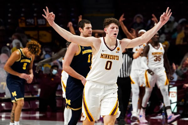 Minnesota's Liam Robbins (0) celebrates his three-point shot against Michigan in the second half of an NCAA college basketball game, Saturday, Jan. 16