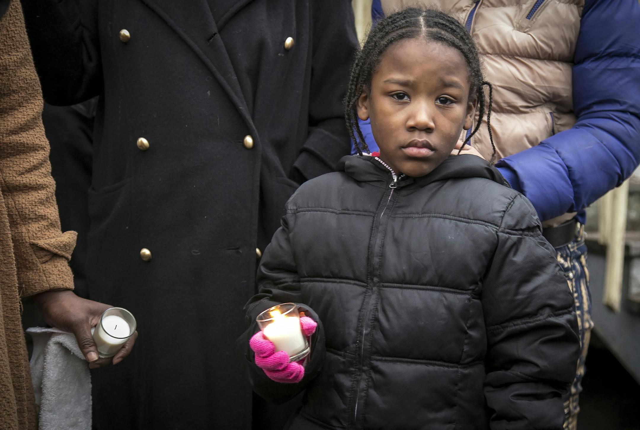 A child holds a candle during a vigil outside Bettie Jones' home on Sunday, Dec. 27, 2015, in Chicago. Jones and Quintonio LeGrier, 19, were killed early Saturday by police responding to a domestic disturbance on the city’s West Side, police said. (Ashlee Rezin/Chicago Sun-Times via AP) MANDATORY CREDIT, MAGS OUT, NO SALES; CHICAGO TRIBUNE OUT