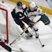 Minnesota Wild defenseman Nick Seeler, right, drives past Colorado Avalanche defenseman Tyson Barrie to wrap around the net for a shot in the first pe