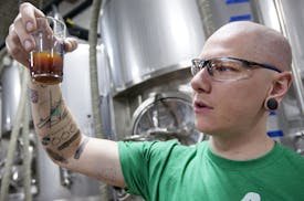 Lee Carter, one of five founders of Big Watt Cold Beverage Co., checked a cold press sample at Burning Brothers Brewing in St. Paul.