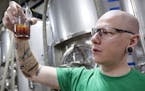 Lee Carter, one of five founders of Big Watt Cold Beverage Co., checked a cold press sample at Burning Brothers Brewing in St. Paul.