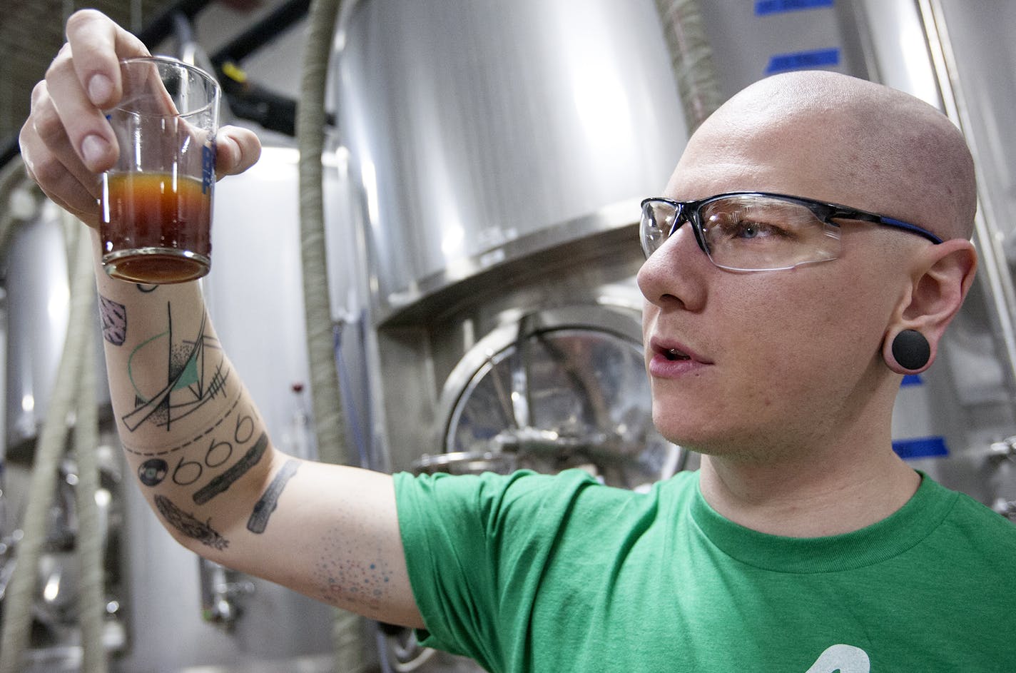 Lee Carter, one of five founders of Big Watt Cold Beverage Co., checked a cold press sample at Burning Brothers Brewing in St. Paul.