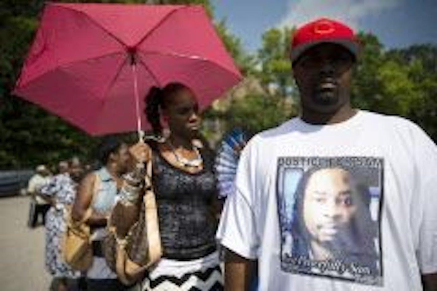 Mourner Bill Smith wears a shirt bearing the likeness of Samuel DuBose as he waits on line outside funeral services for Dubose at the Church of the Living God in the Avondale neighborhood of Cincinnati, Tuesday, July 28, 2015. Dubose was fatally shot by a University of Cincinnati police officer who stopped him for a missing license plate.