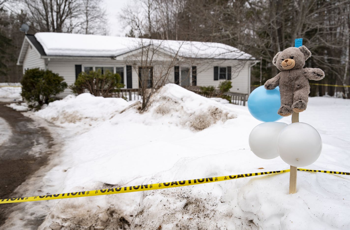 A Teddy bear and a trio of balloons were stuck in the snow in front of the house where Jackie DeFoe and her 18-month-old son, Kevin, were found dead Saturday. Cloquet police were monitoring the property Monday morning.