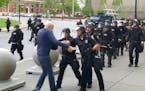 A Buffalo police officer appears to shove a man who walked up to police Thursday, June 4, 2020, in Buffalo, N.Y.