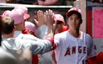 Angels starter Shohei Ohtani was greeted in the dugout after the top of the first inning against the Twins on Sunday.
