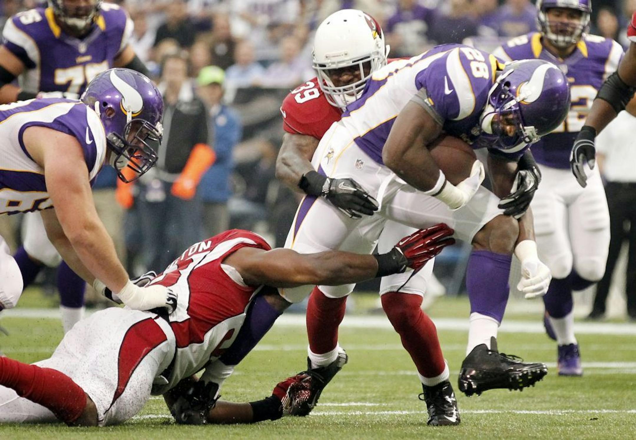 Minnesota Vikings running back Adrian Peterson (28) ran through Cardinals defenders on his way to score a touchdown in the first quarter.