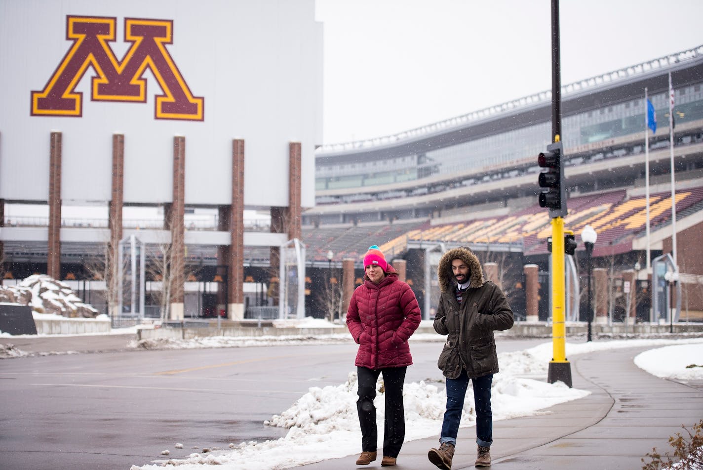 Haley Kimmet walked near TCF Bank Stadium while being given a tour of the University of Minnesota Campus by friend Sohail Akhavein on Friday afternoon. ] (AARON LAVINSKY/STAR TRIBUNE) aaron.lavinsky@startribune.com For the first time in nearly 40 years, the Minnesota Vikings are hosting a playoff game outside. With possible below-zero temperatures in the forecast for Sunday's kickoff with Seattle, we take a look at what fans, players and TCF Bank Groundskeepers are doing in preparation for the b