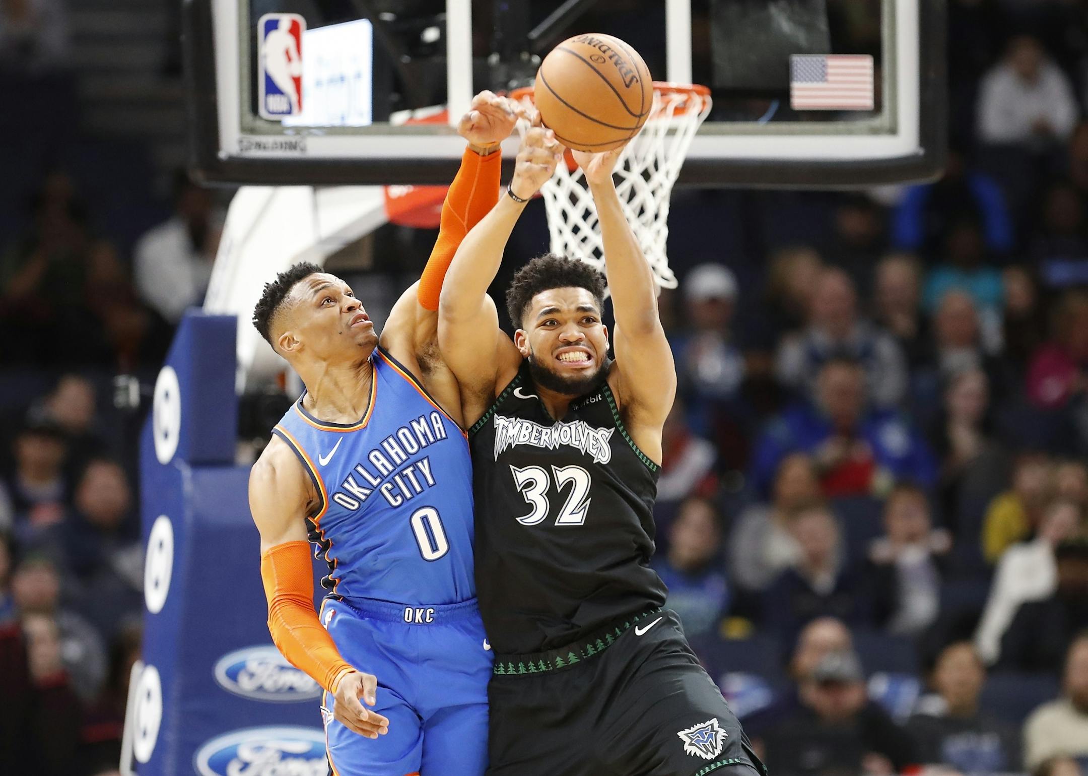 Minnesota Timberwolves center Karl-Anthony Towns (32) and Oklahoma City Thunder guard Russell Westbrook (0) battle for the ball during the first half.