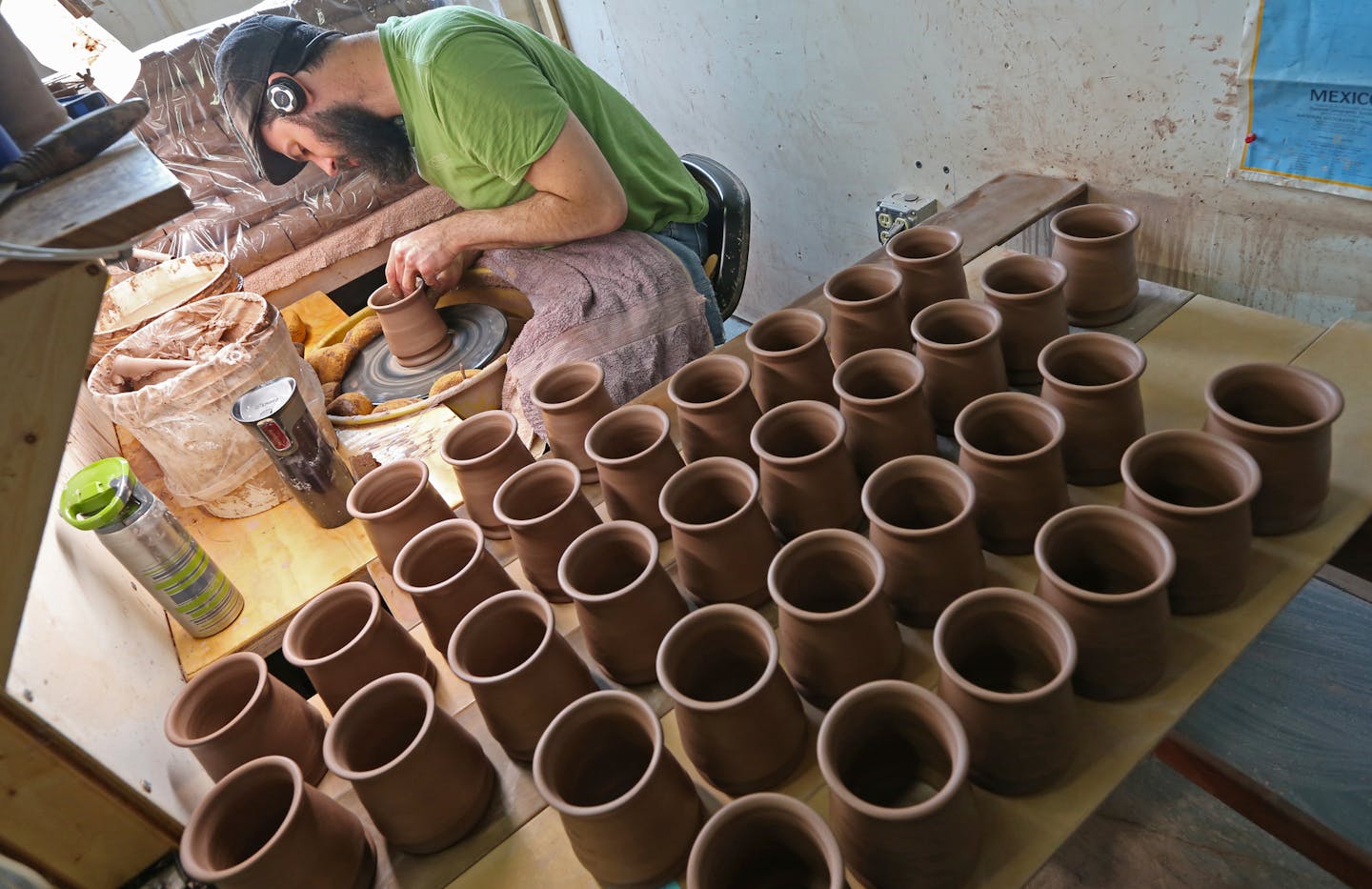 Deneen Pottery employee Jonathan Conrad hand formed mugs on a pottery wheel on 4/30/14. Profile on Deneen Pottery, a small St. Paul company that makes custom stoneware and coffee mugs the old-fashioned way, by tossing a lump of clay on a potter's wheel. The company is growing by leaps and bounds, doubling its number of employees to more than 50 over the last couple of years. They even have a dog wandering the factory and shop.] Bruce Bisping/Star Tribune bbisping@stribune Jonathan Conrad/source