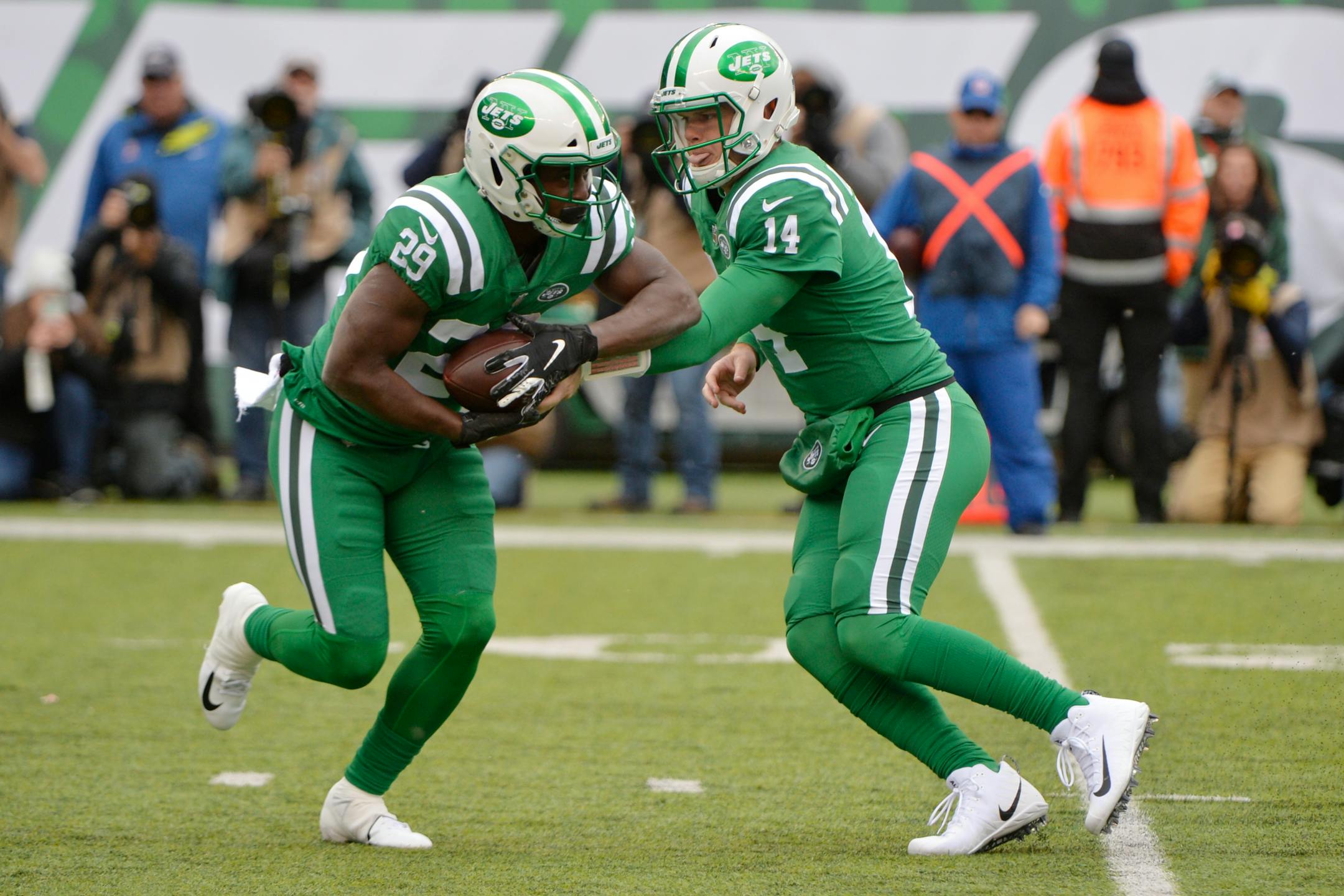 Sam Darnold hands the ball to running back Bilal Powell during the first half.