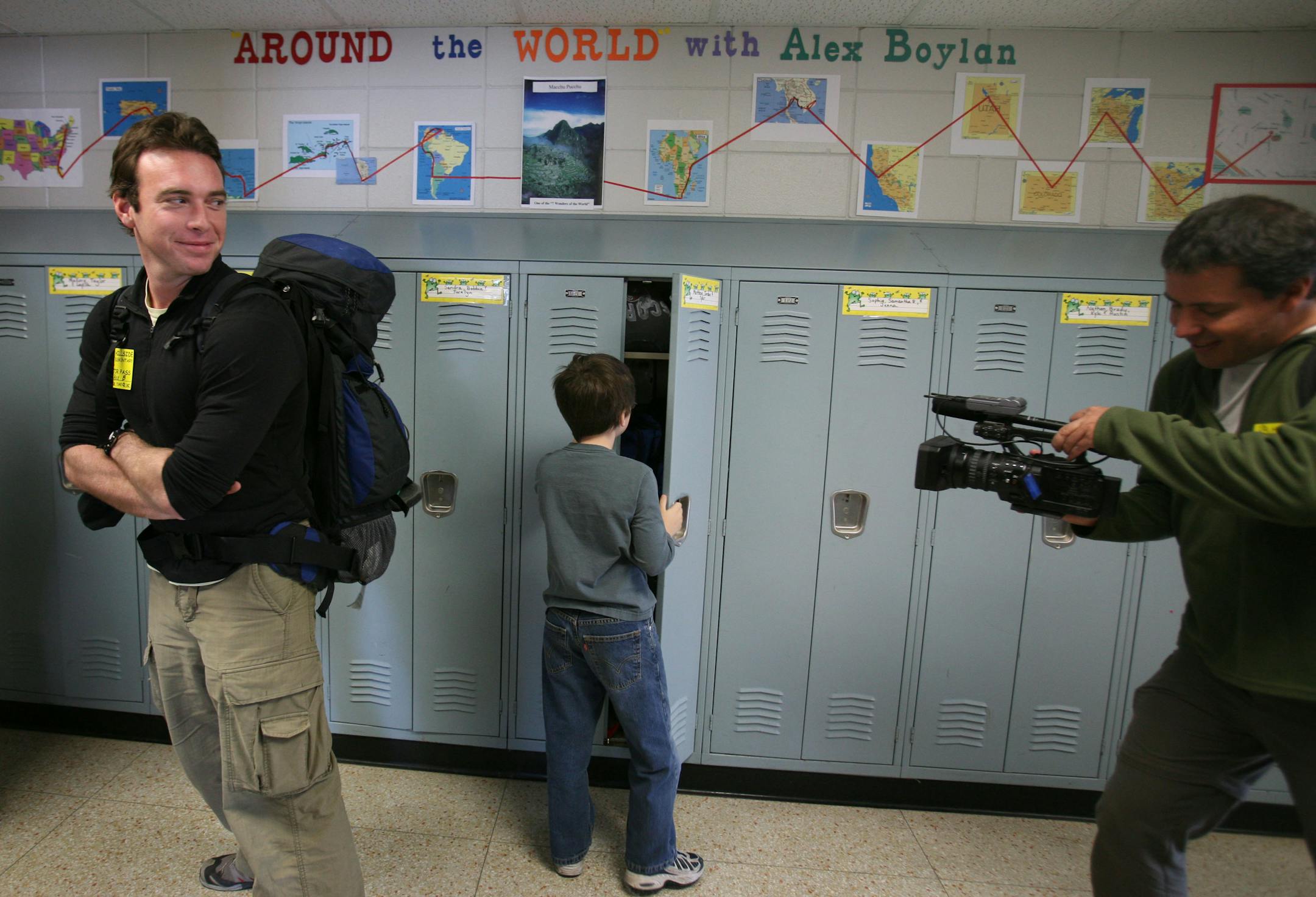 Alex Boylan smiled back at his travel partner and cameraman, Zsolt Luka , as third grader Jordan Thompson closed his locker at Hillside Elementary in Cottage Grove. The duo toured the school and answered students' questions about their worldwide travels.